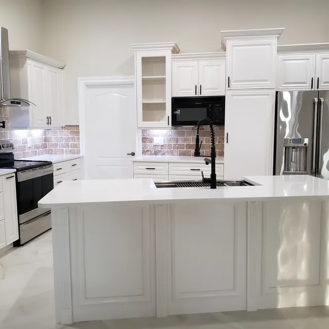 Kitchen island with white cabinetry and stainless appliances