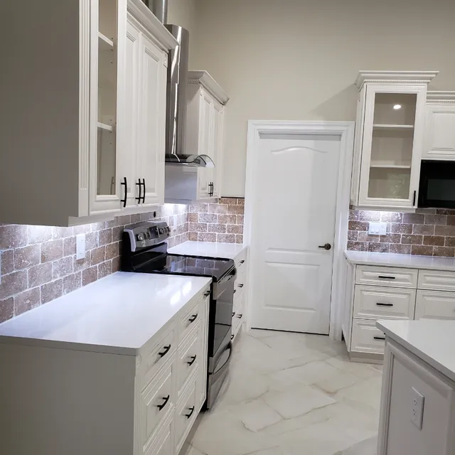 Remodeled kitchen with brick backsplash and white quartz counters