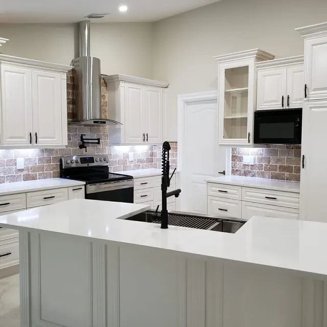 Open kitchen with island sink and glass-front upper cabinets