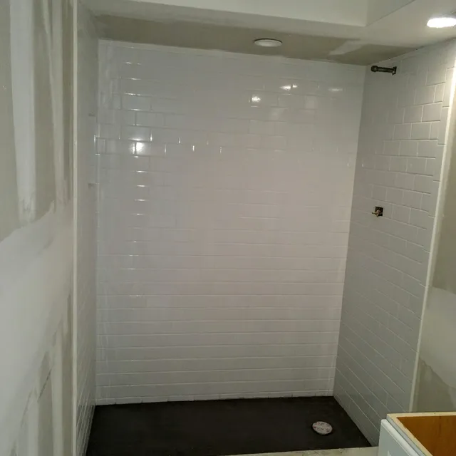 Floor-to-ceiling white subway tile shower