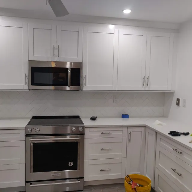 White kitchen cabinets with stainless microwave and range