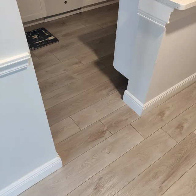 New flooring and white baseboards around a column