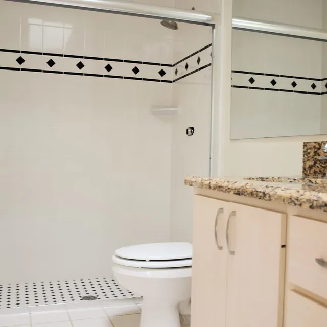 Bathroom with diamond-pattern tile border and vanity